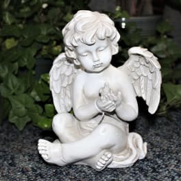 White angel figurine holding a small bird