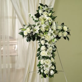 White floral cross arrangement on a stand