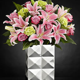 Pink lilies and roses in a white geometric vase
