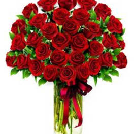 Bouquet of red roses in a clear glass vase with a red ribbon