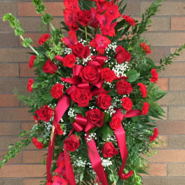Tall red floral standing spray with roses and ribbons