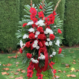 Standing red and white floral spray with ribbon on a wire easel