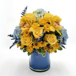 Yellow roses and daisies in a blue glass vase