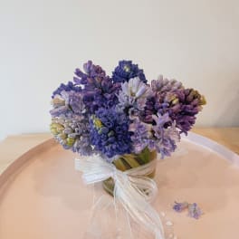 Purple and lavender flower bouquet tied with a white ribbon