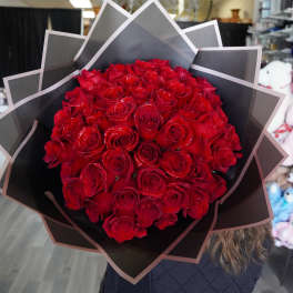 Large bouquet of red roses wrapped in black paper