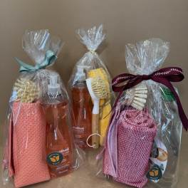 Three wrapped cleaning gift sets with soap bottles and scrub brushes