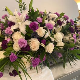 Large white and purple floral casket spray with roses and lilies