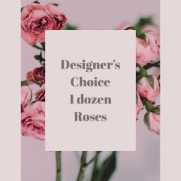 Pink roses arranged around a card that reads Designer's Choice 1 dozen Roses.