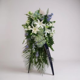 Standing floral spray with white lilies and blue-purple flowers