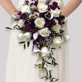 Bridal bouquet of white roses and purple flowers with trailing calla lilies
