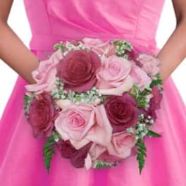 Pink and burgundy rose bouquet held against a bright pink dress