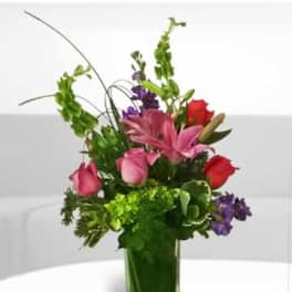 Pink and red flowers arranged in a clear glass vase