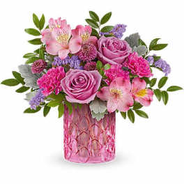 Pink and lavender flower arrangement in a pink glass vase