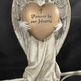 Angel figurine holding a heart plaque with the words Forever in our Hearts
