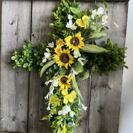 Cross-shaped floral arrangement with yellow sunflowers and white blossoms