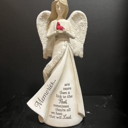 White angel figurine holding a red bird with a memorial message on the robe