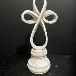 White decorative cross on a carved pedestal base