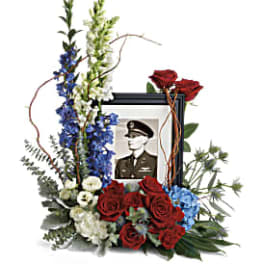 Memorial floral frame with red roses, blue and white flowers, and a portrait
