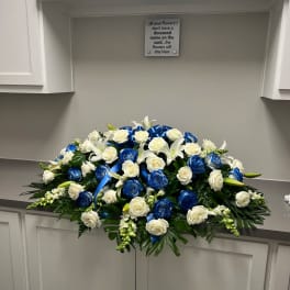 Large white and blue rose funeral spray with ribbon