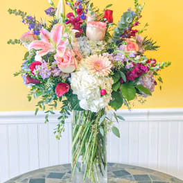 Mixed bouquet in a clear glass vase with pink, white, and purple flowers