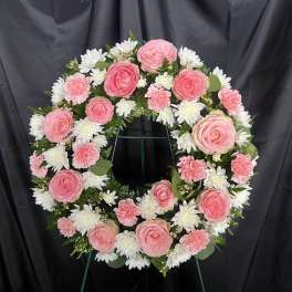 Pink and white floral wreath on a stand