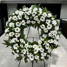 White daisy wreath on a black stand