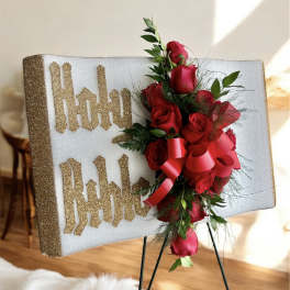 Red rose arrangement on a glittery display board with gold lettering