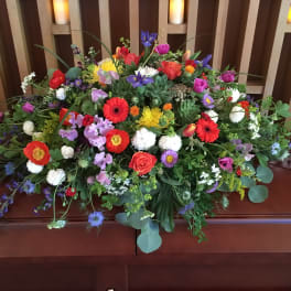Large colorful floral casket spray with mixed blooms