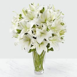 White lilies arranged in a clear glass vase