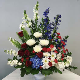 Mixed bouquet in a white vase with red, white, and blue flowers