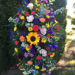 Large standing spray with multicolored flowers on a black easel