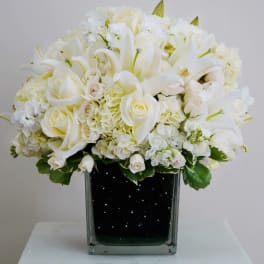 White floral arrangement in a square glass vase