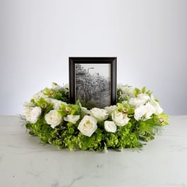 White floral wreath around a framed black-and-white photo