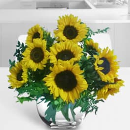Bouquet of yellow sunflowers in a clear glass vase