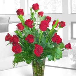 Red roses arranged in a clear glass vase