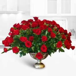 Large arrangement of red roses in a gold pedestal vase