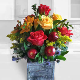 Mixed bouquet of red and yellow roses in a blue wooden container