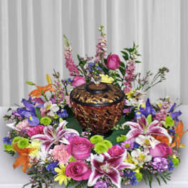 Colorful floral arrangement surrounding a decorative urn
