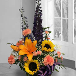 Tall floral arrangement with sunflowers, orange lilies, and pink carnations