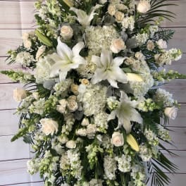 Large white funeral spray with lilies, roses, and hydrangeas