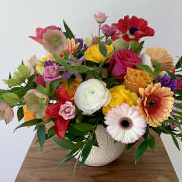 Mixed bouquet of colorful flowers in a patterned ceramic vase