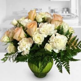 Peach and white roses with white carnations in a green vase