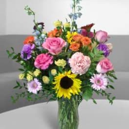 Mixed bouquet of colorful flowers in a clear glass vase