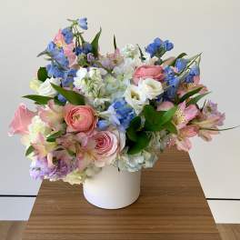 Pastel bouquet of mixed flowers in a white vase