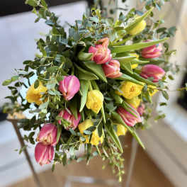 Bouquet of pink and yellow tulips with greenery