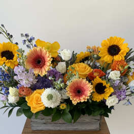 Colorful mixed flower arrangement in a wooden box