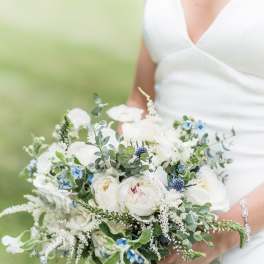 Bride holding a white and blue wedding bouquet