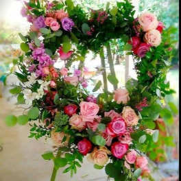 Heart-shaped floral wreath with pink and purple roses and greenery