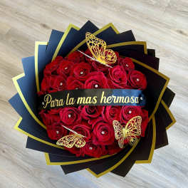 Red rose bouquet with gold butterfly decorations and a black ribbon