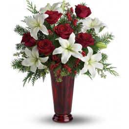 Tall red vase arrangement with red roses, white lilies, and red berries.